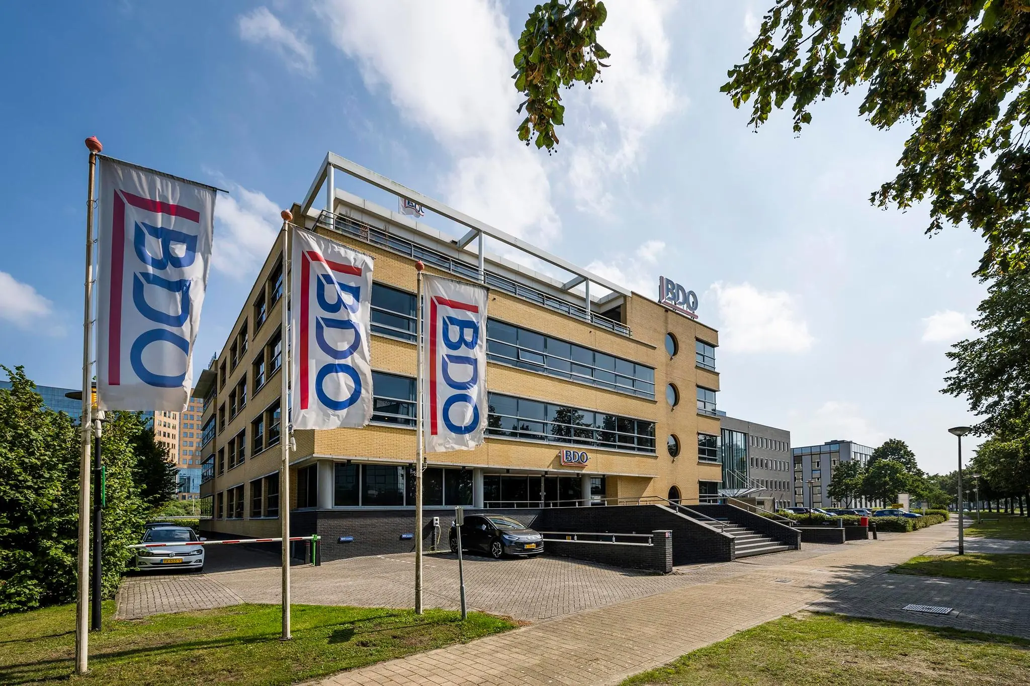 Kantoorpand van BDO aan de K.P. van der Mandelelaan met drie vlaggen met het BDO-logo ervoor.